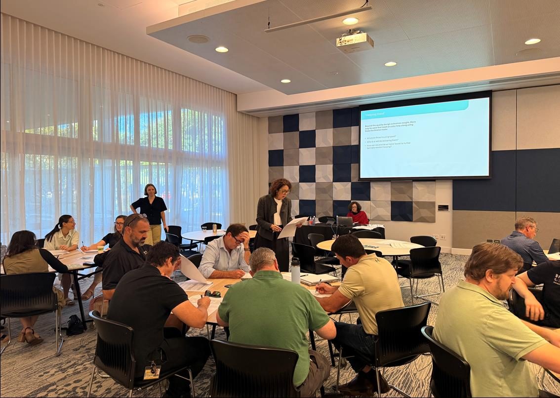 Participants collaborating around tables during a project Design Hub workshop